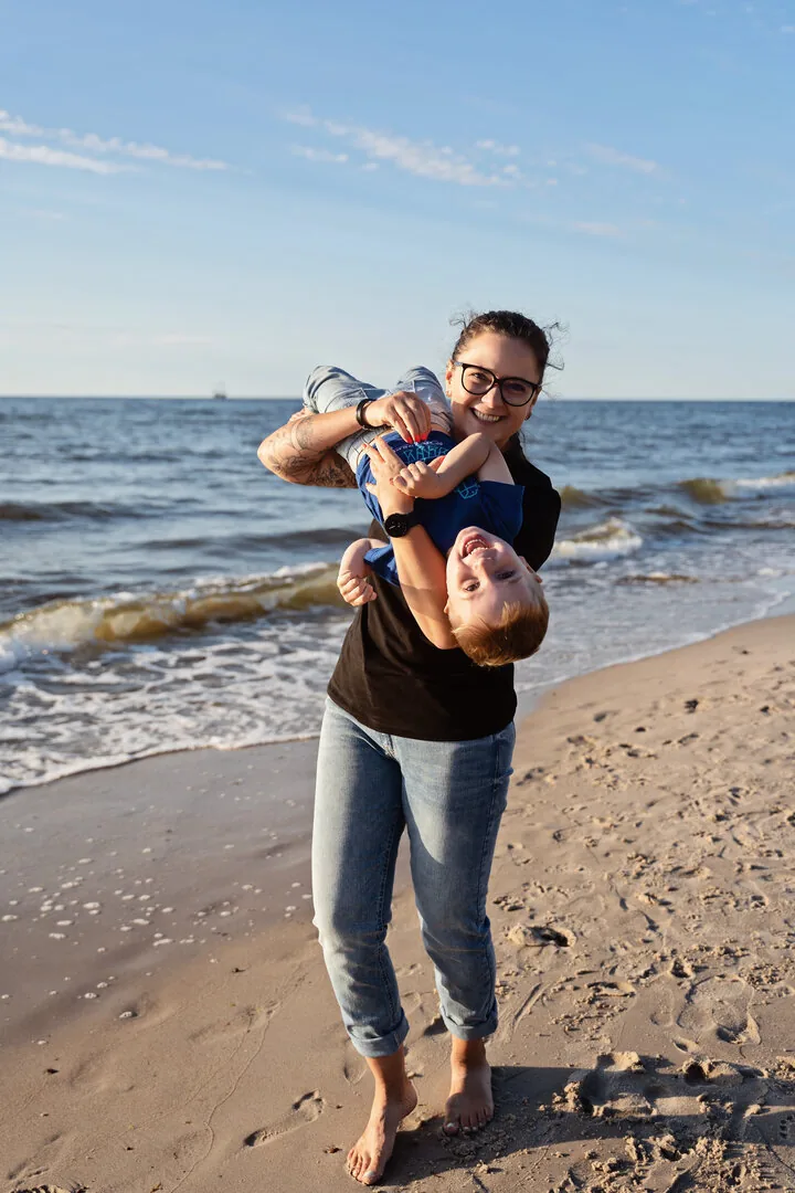 Mama bawiąca się z dzieckiem przy brzegu morza
