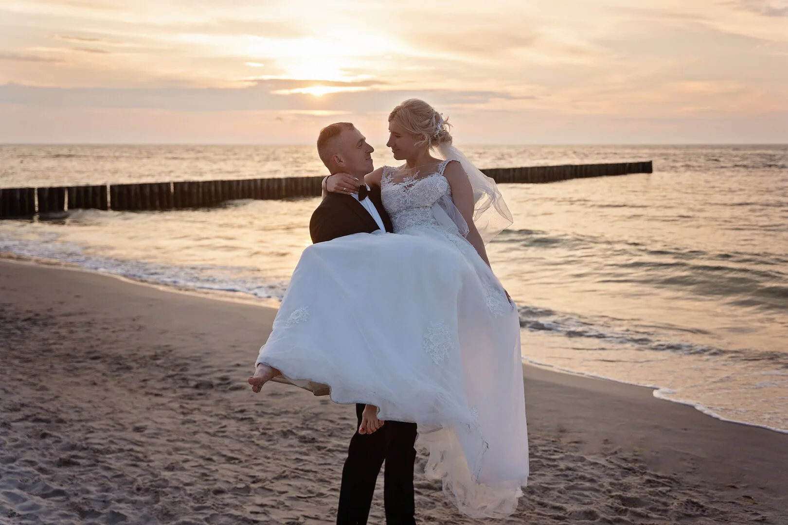 Couple in coordinated clothes during a sunset beach photoshoot