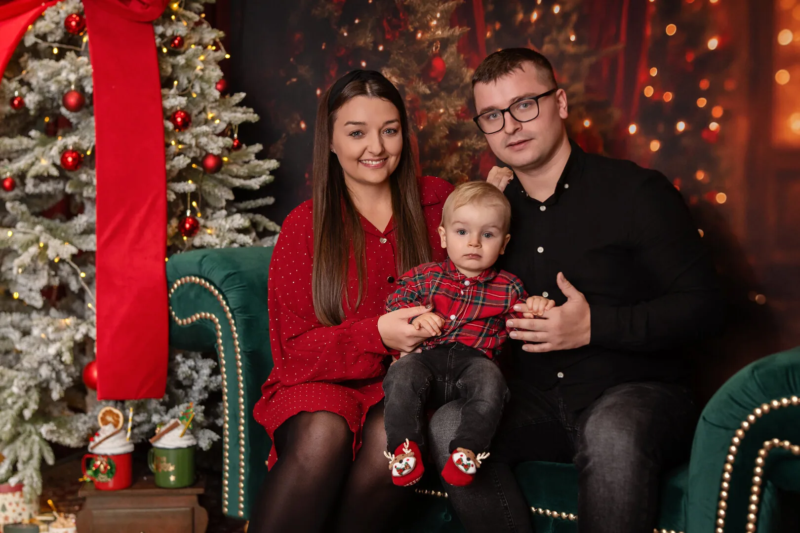 Rodzinny portret na zielonej kanapie w świątecznej aranżacji