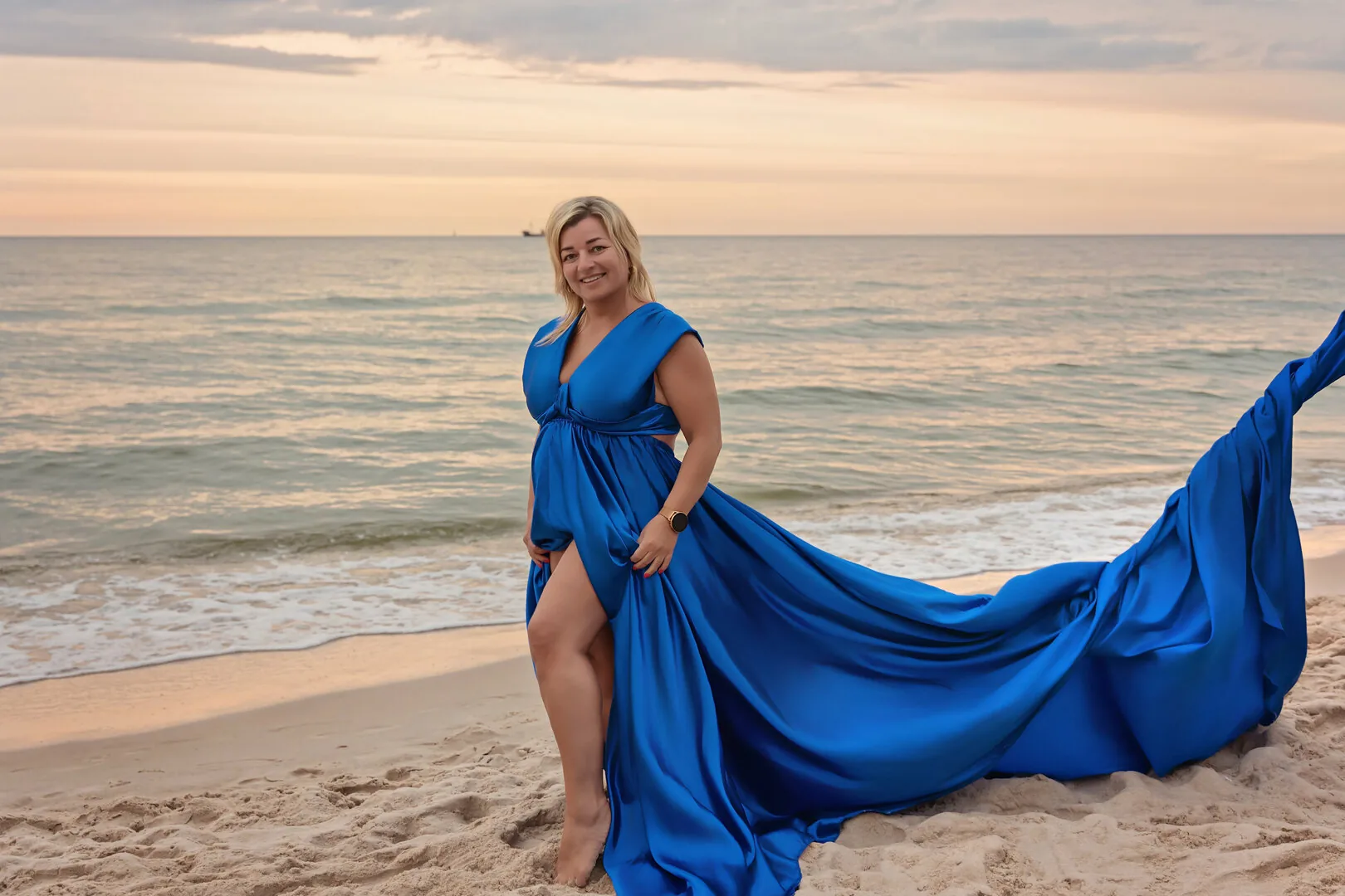 Przyszła mama w niebieskiej sukni Flying Dress na plaży