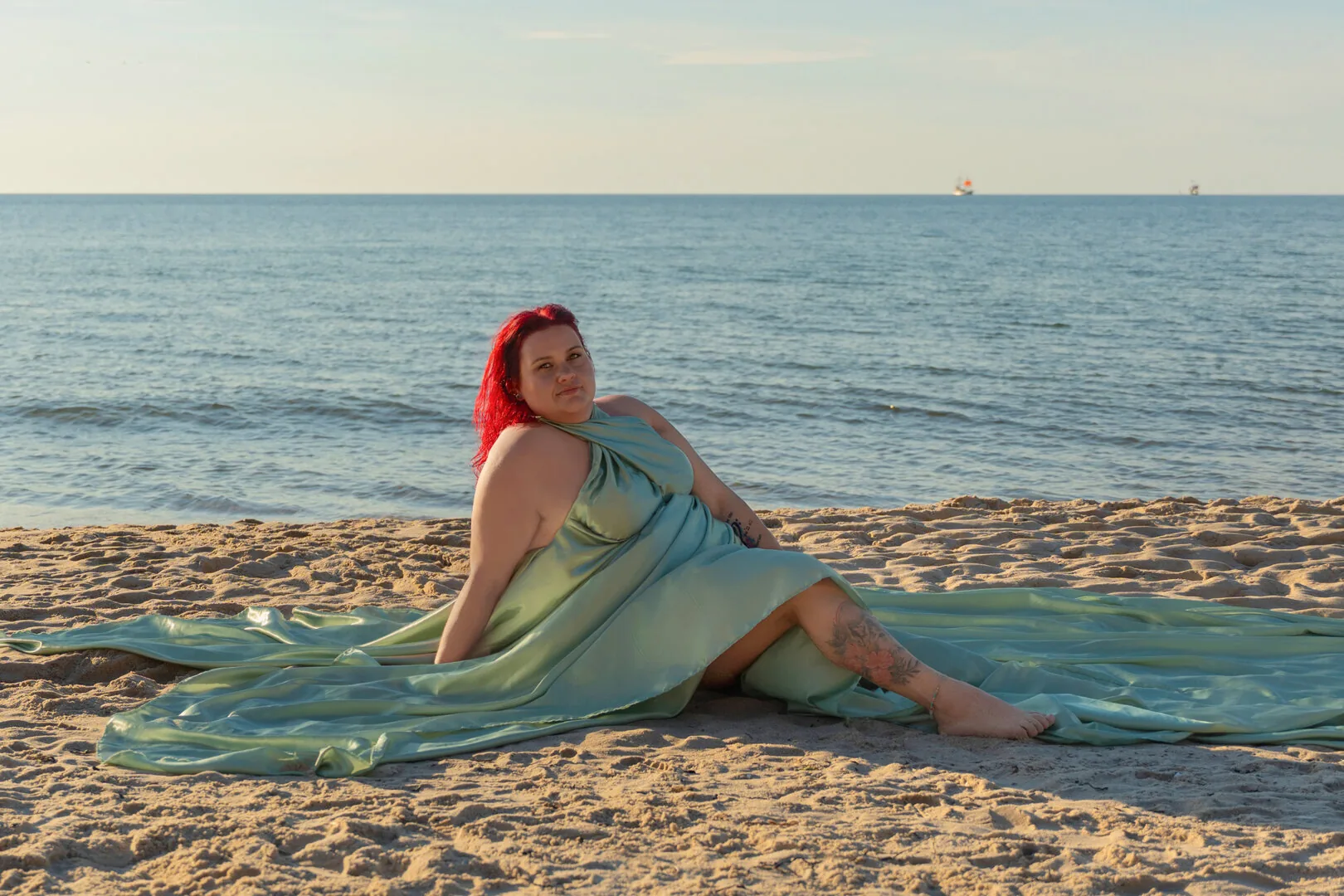 Woman in a sage Flying Dress beside the sea
