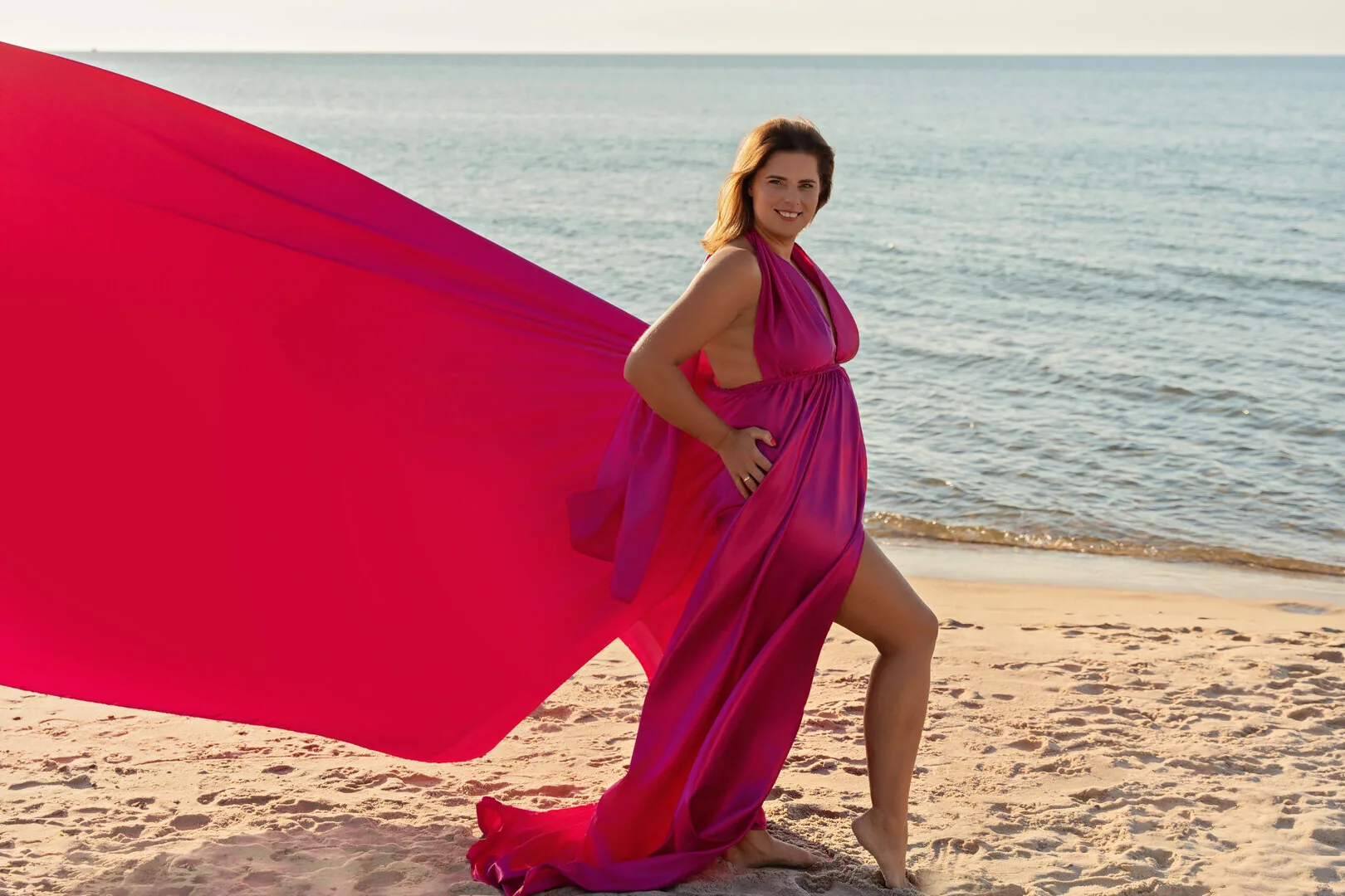 Woman in a fuchsia Flying Dress with a windblown train