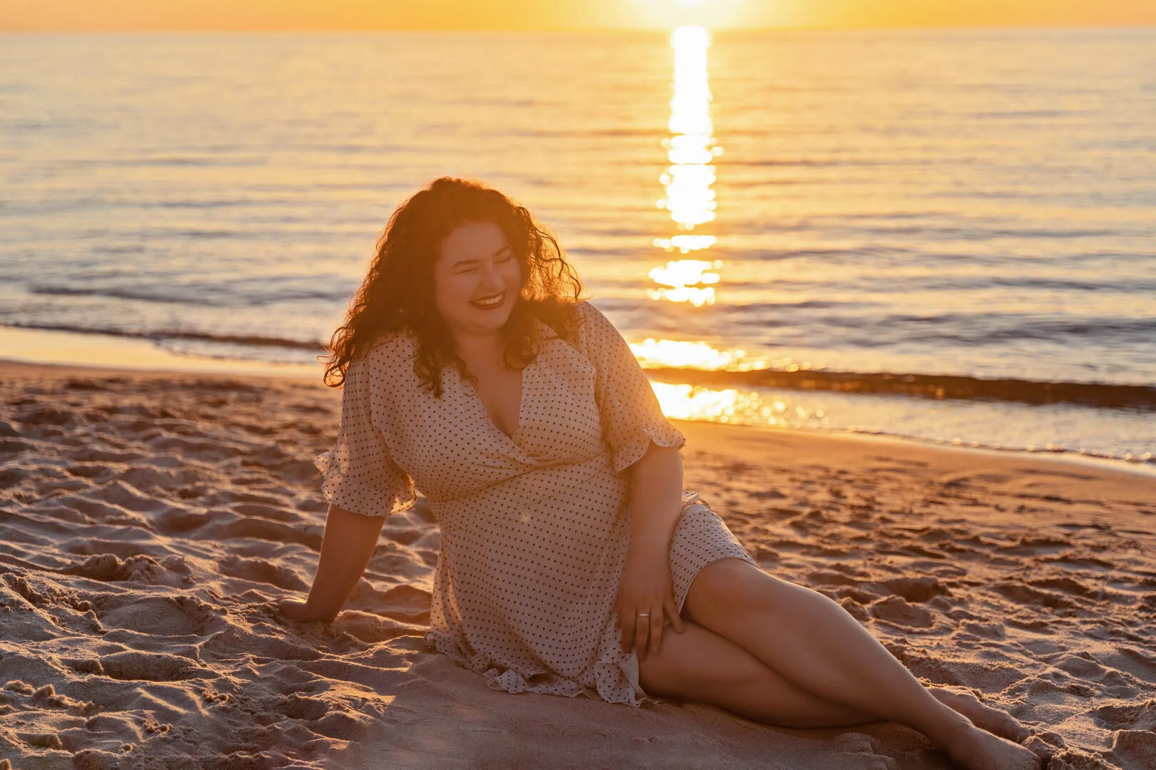 Kobieta w zwiewnej sukience na plaży w złotym świetle