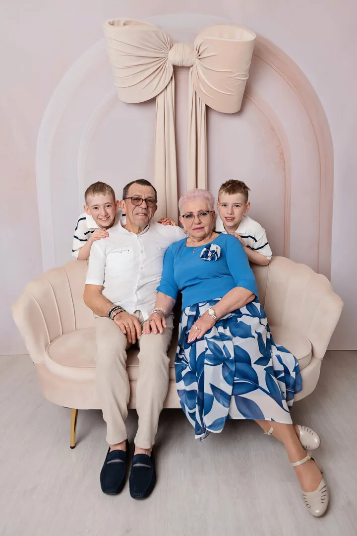 Dziadkowie z trójką wnuków na fotelu w studio