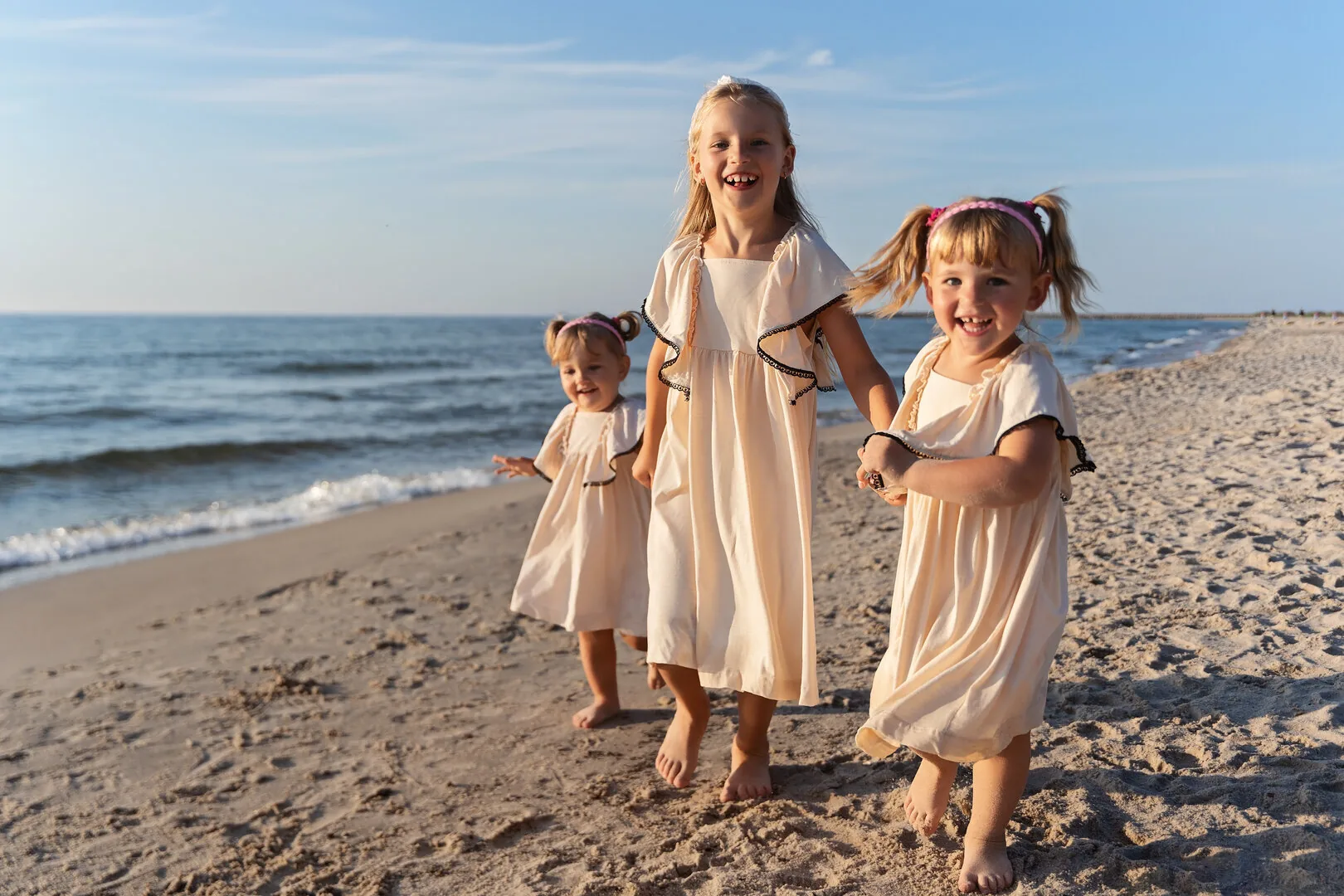 Trzy siostry biegnące po plaży