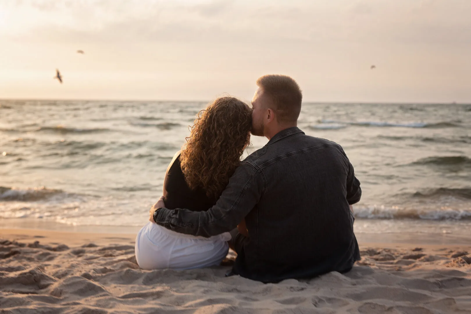 Couple walking along the beach during a photoshoot in Kołobrzeg